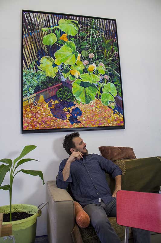 Dominic Virtosu the artist in his studio with the original framed oil painting a quiet corner